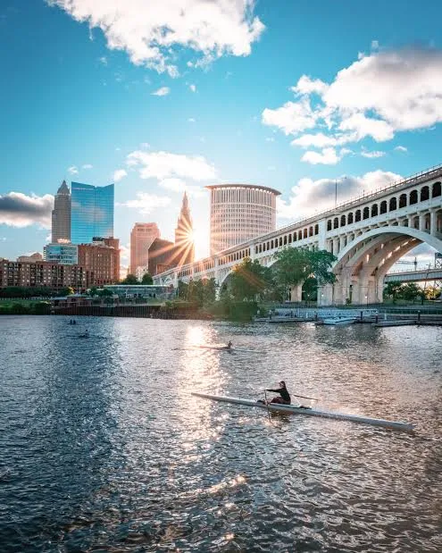 Downtown Cleveland from the Cuyahoga River, with a rower and the Veterans Memorial Bridge.